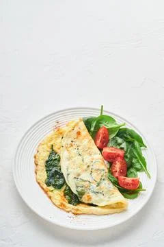 Omelet or omelette with spinach, cherry tomato and pepper seasoning on a whit Stock Photos
