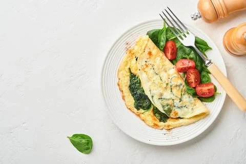 Omelet or omelette with spinach, cherry tomato and pepper seasoning on a whit Stock Photos