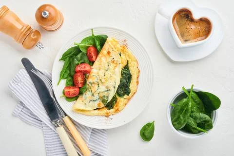 Omelet or omelette with spinach, cherry tomato and pepper seasoning on a whit Stock Photos