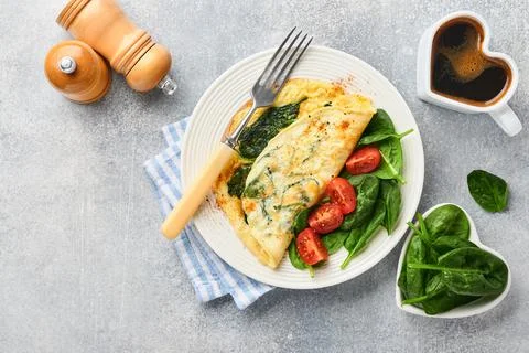 Omelet or omelette with spinach, cherry tomato and pepper seasoning on a whit Stock Photos