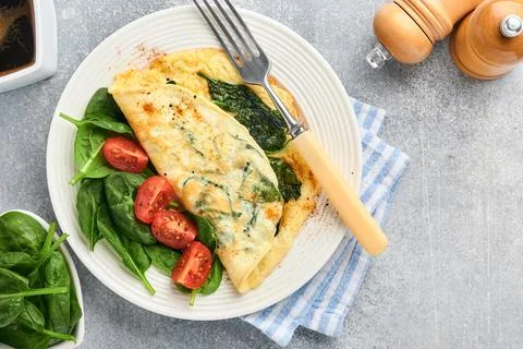 Omelet or omelette with spinach, cherry tomato and pepper seasoning on a whit Stock Photos