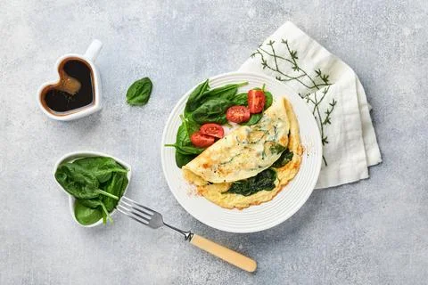 Omelet or omelette with spinach, cherry tomato and pepper seasoning on a whit Stock Photos