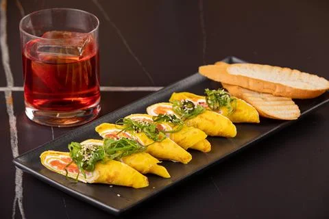 Omelet with salmon, cheese and knocks on a black plate. Keto diet menu concep Stock Photos