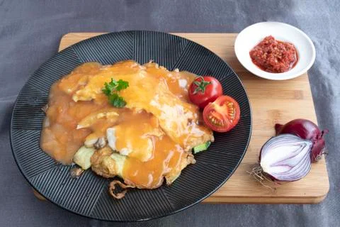 Omelet served with several type of vegetables and tomatoe sauce Фото
