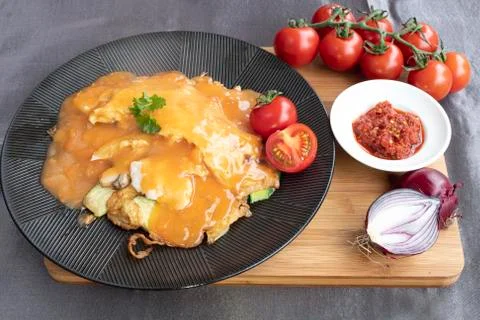 Omelet served with several type of vegetables and tomatoe sauce Stock-Fotos