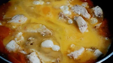 Omelet with tomato and chicken is fried in a hot frying pan. Stock Footage 80939724