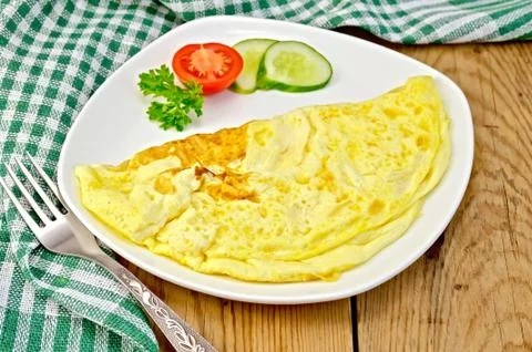 Omelet with vegetables and fork on a board Stock Photos