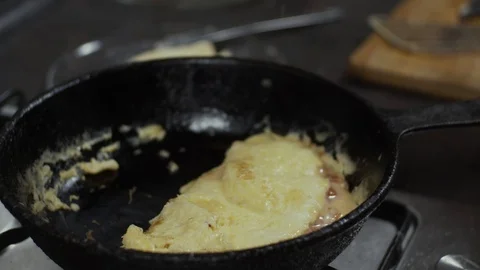 Omelette cooking on frying pan adding cheese Stock Footage 125989158