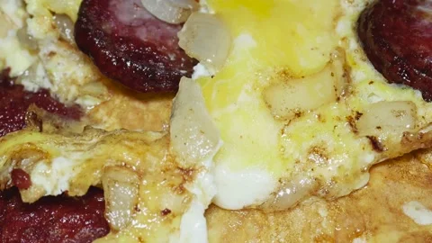 Omelette from eggs and sliced fried sausage with crust, macro Видео 231541149
