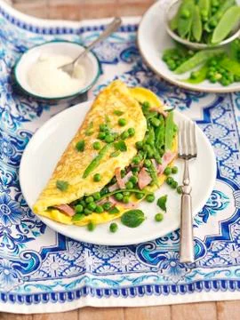 Omelette with peas, mange tout, ham and Pecorino Stock Photos