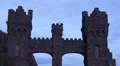 Ominous castle entrance stands before greying sky with clouds HD Footage