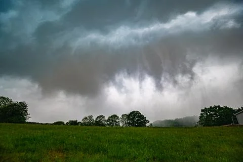 Ominous clouds with falling rain during a severe thunderstorm Stock Photos