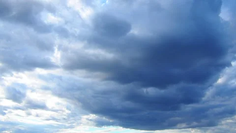 Ominous clouds fill the sky over a tranquil landscape, casting shadows as the Stock Footage 317499307