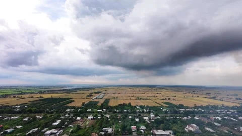 Ominous monsoon rain clouds hovering above golden agricultural land Stock Footage 337756921