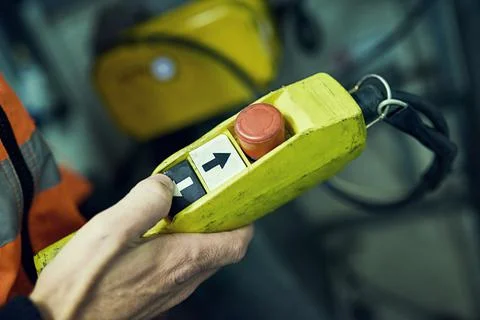 The ominous red button. an unidentifiable engineer holding a control switch in Stock Photos