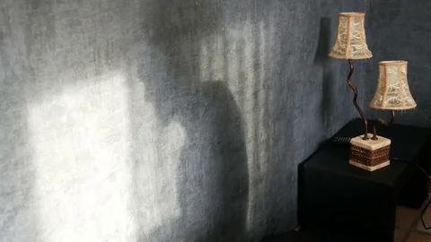 An ominous shadow in a gothic dark room next to a vintage yellow lamp, angrily Stock Footage 81439838