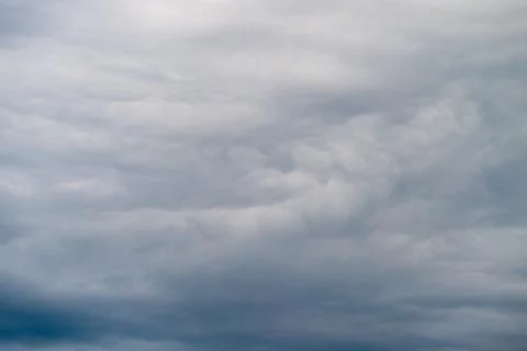 Ominous storm clouds brewing with motion, deep slate tones and heavy texture, 写真素材