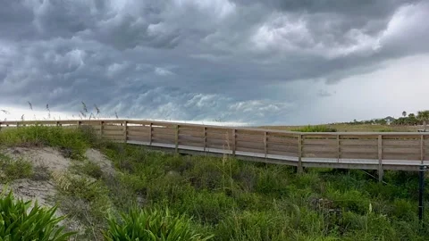 Ominous Storm Clouds Gather Over Ocean Beyond Beach Dunes Stock Footage 345553795