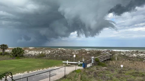 Ominous storm clouds rolling in over coastal beach, ocean and dunes 動画素材 292765033