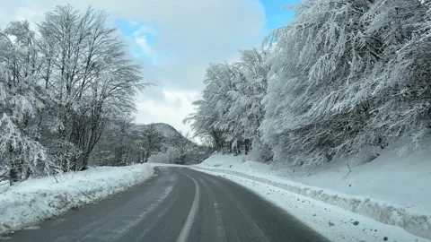 Onboard camera view of driving on icy road in through winter mountian forest  Stock Footage 325625598