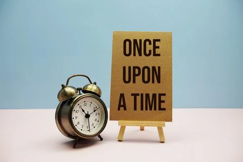 Once upon a time text with easel and alarm clock on blue and pink background Stock Photos