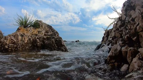 Oncoming sea waves during tide on rocky coast with plants Stock Footage 114030104