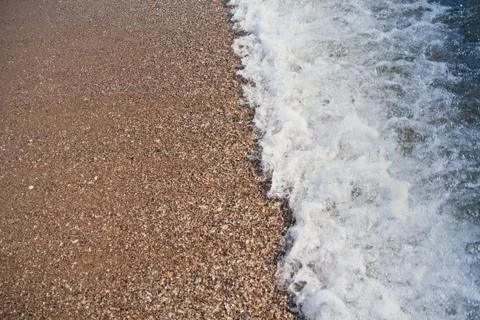 Oncoming waves on a beach sand. Backgrounds and textures Stock Photos
