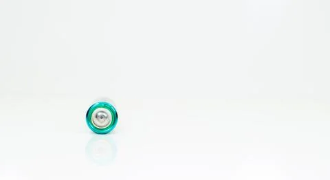 One alkaline battery on a white background with reflection. Energy supply and Stock Photos