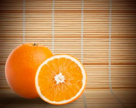 One and half oranges on bamboo mat background Stock Photos