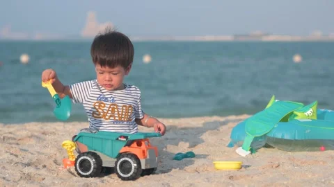 One and half year old baby boy playing with toy truck on the beach Vidéo 336494243
