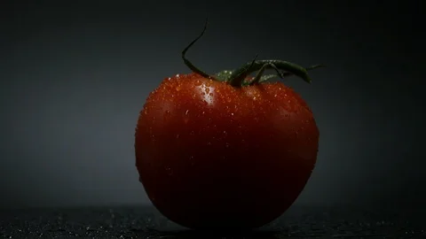One appetizing ripe tomatoes on a mirror black background. Rotating table 스톡 동영상 108827360