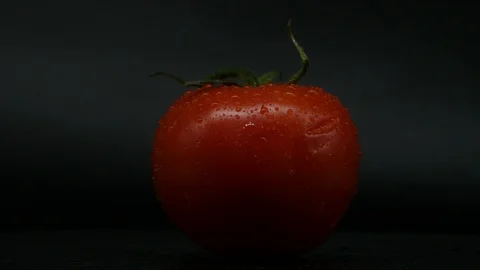 One appetizing ripe tomatoes on a mirror black background. Rotating table 動画素材 108827378