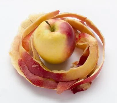One apple surrounded by another's apple peelings Stock Photos