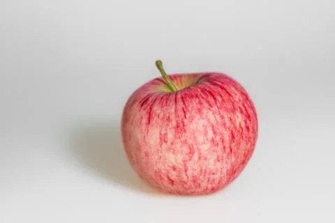 One apple on white background. Red juicy ripe apple close up. Stock Photos