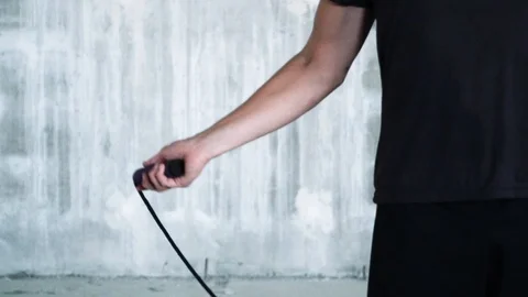 One arm of energetic man skipping jump rope in industrial scenery Stock Footage 112653812