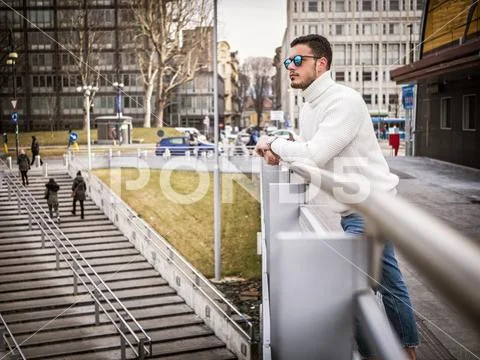 One attractive man in city setting wearing white sweater Stock Photos