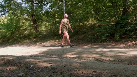 One bald guy is hiking in the mountains on a sunny bright day Video stock 248869062