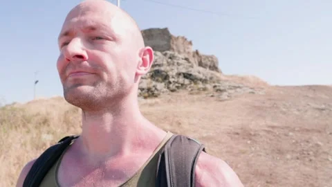 One bald guy is hiking in the mountains on a sunny bright day Video stock 248869086