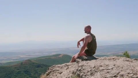 One bald guy is hiking in the mountains on a sunny bright day Stock Footage 248871047