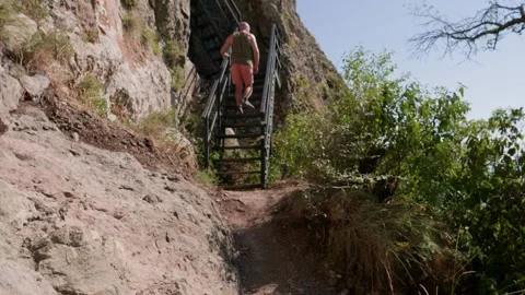 One bald guy is hiking in the mountains on a sunny bright day Stock Footage 248871276