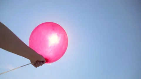 One Balloon on a background of blue sky. a balloon in the girl's hand. Stock Footage 154723882
