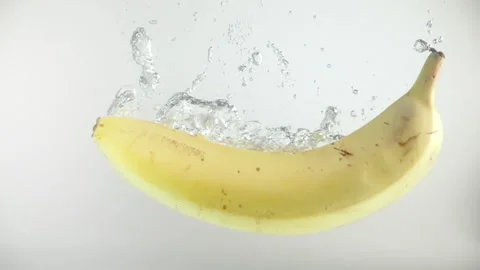 One banana fall into the water with splashes and bubbles in slow motion Video stock 144445563