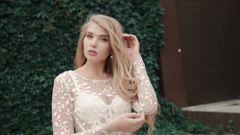 One beautiful blonde posing for camera while standing at street on summer day. Stock Footage 148009609