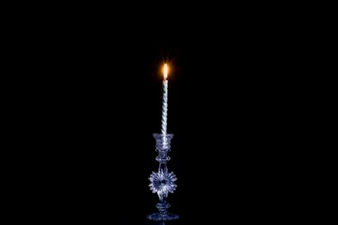 One Beautiful silver candle burns in a crystal candlestick on a dark backgrou 写真素材