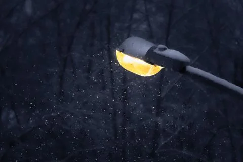 One beautiful yellow street rectangular lighting lantern with white snow is on a Fotos Stock