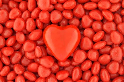 One big candy heart in the middle on small valentine candies Stock Photos