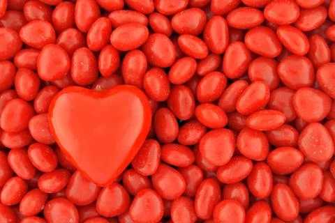 One big candy heart on top of small valentine candies Stock Photos