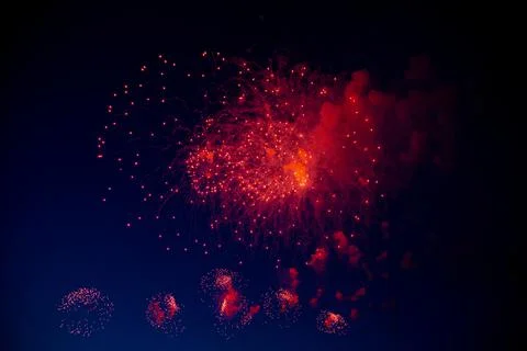 One big red firework with a bright red center hanging against the background of Stock Photos