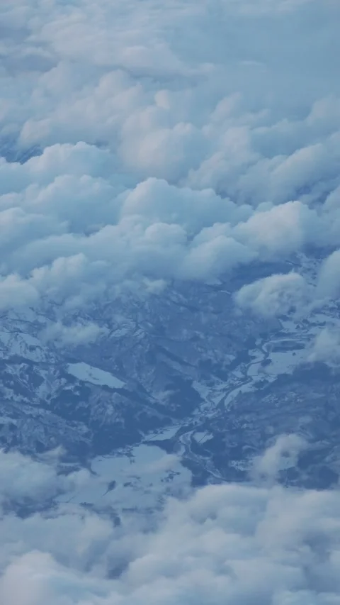One bird's-eye view of clouds, snowy summits, and icy rivers through the window. 库存影片 330542176