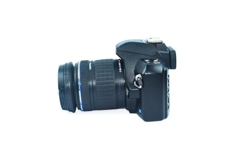 One black colored digital camera with a nice lens attached to it on top of wh Stock Photos
